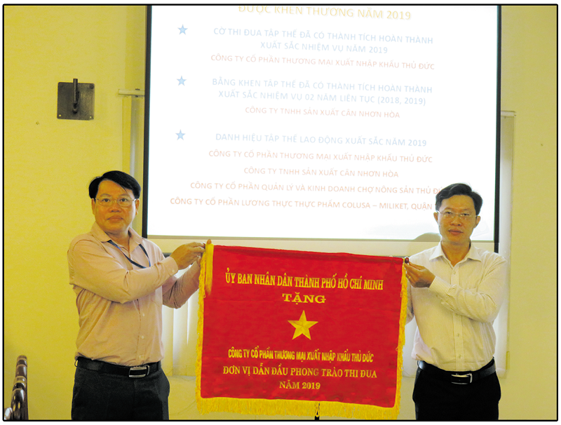Ông Trần Thanh Quang (bên trái) trao cờ thi đua cho ông Hoàng Long Quân ( bên phải) đại diện công ty Cp Thương mại XNK Thủ Đức.